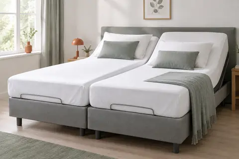 Protège-matelas blanc en coton sur un lit articulé, avec un coin relevé montrant le dessous imperméable.